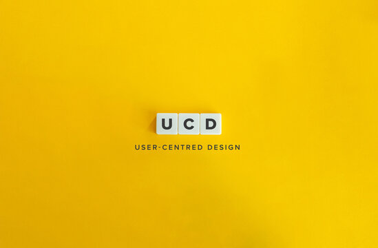 UCD Initialism for User-Centred Design (UX Design). Letter Tiles on Bright Orange Background.