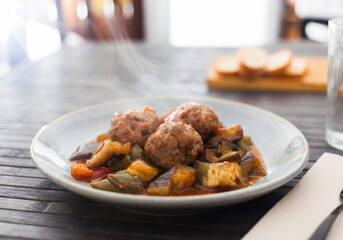 Steamed meatballs with stewed vegetables with haze on plate