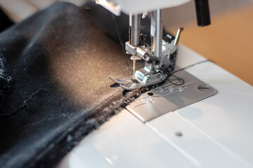 Sewing machine needle and black cloth closeup