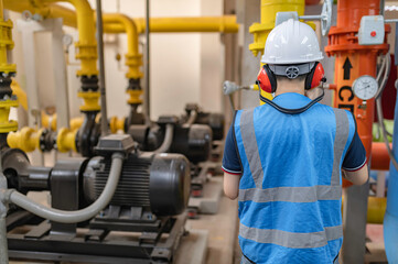 Maintenance technician at a heating plant,Petrochemical workers supervise the operation of gas and oil pipelines in the factory,Engineers put hearing protector At room with many pipes