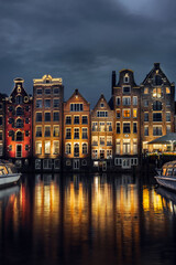 Night dancing houses at Amsterdam canal Damrak, Holland, Netherlands.