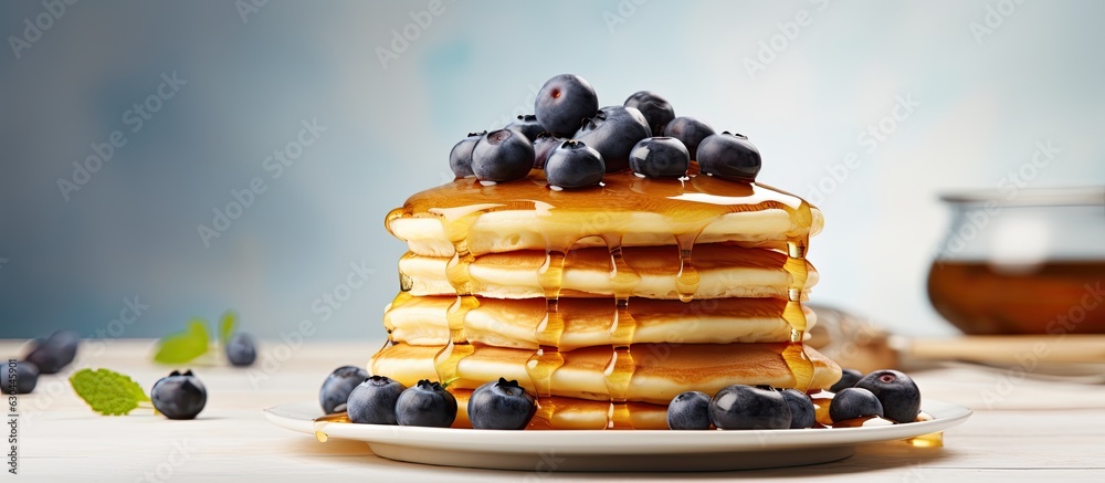 Poster american pancakes topped with blueberries and maple syrup on a light background. perfect for a sweet