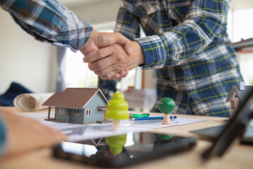 Architects and engineers join hands to congratulate when discussing and successful cooperation in planning construction project. Team of engineers and architects join hands in office after successful