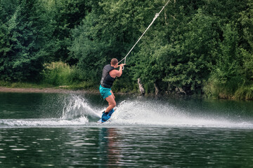 Wakeboarding on the sea on summer day in life jacket. Soft focus. Action blur.