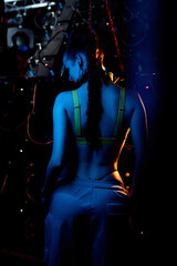 Beautiful go-go dancer posing in a nightclub. Stands on the back. atmospheric blue light. Party...