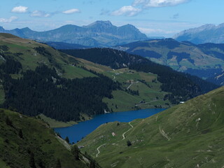 Lac de Roselend et chaîne des Aravis, massif du beaufortain, alpes françaises. Ciel bleu, alpages, forêts, lac, paysage.