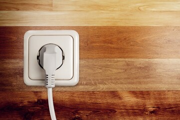 White classic electrical plug in socket on a wall