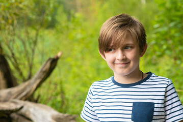 adorable smiling boy in the park. portrait of a happy little child in a striped t-shirt.