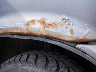 Rust on the fender of the car close-up. Corrosion of the car body, rust-beater, rusted away.