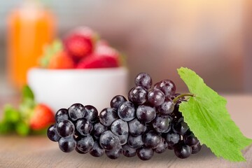 A bunch of ripe fresh blue grapes on desk