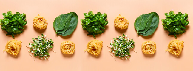 Dry pasta nests and fresh herbs on beige background