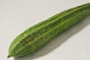 A gambas or luffa gourd isolated on a white background.