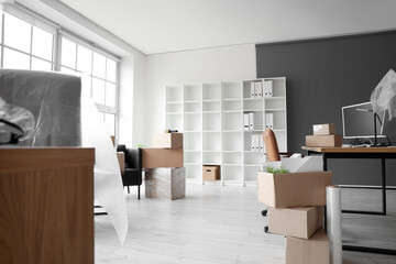 Workplace with cardboard boxes in office on moving day