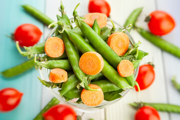 green pea carrot on wood background
