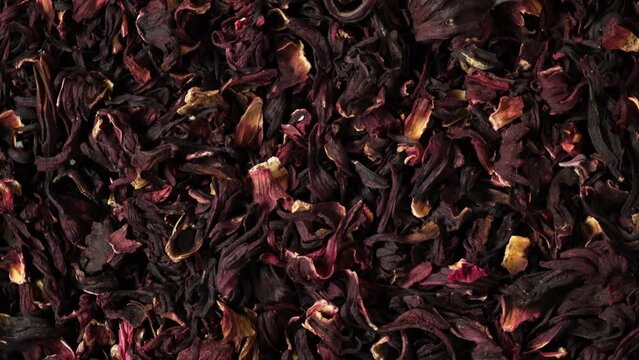 Dried hibiscus petals or Hibiscus sabdariffa, top view. 4K Video, Rotating. Karkade petals used to make herbal tea and delicious infusion.