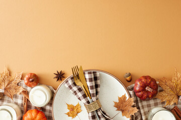 Fall table arrangement idea. Top view of plate, cutlery, tablecloth, raw pumpkins, candles, dry leaves, napkin, anise, cinnamon sticks, acorn on pastel brown background with blank space for ad or text