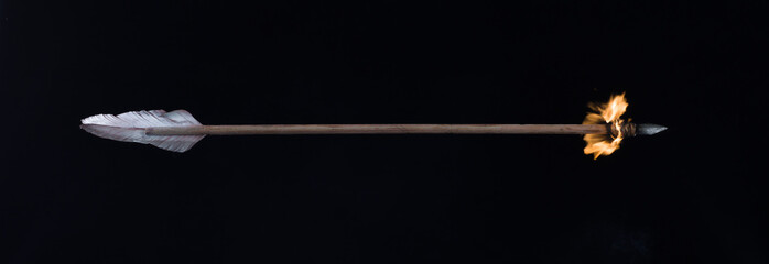 flying burning arrow on black background