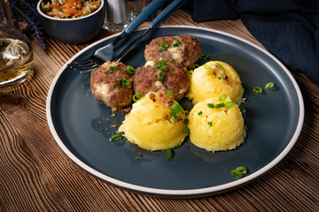 Meatballs with cheese served with boiled potatoes.