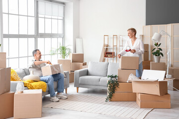 Mature couple packing things in room on moving day