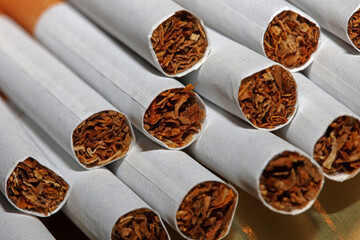 Many cigarettes in colorful background close up of a roll tobacco in paper with filter tube no...