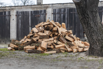 pile of firewood lying in the yard in front of the house (selective focus)