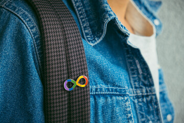 Young boy with autism infinity rainbow symbol sign. World autism awareness day, autism rights movement, neurodiversity, autistic acceptance movement