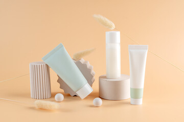 Group of white and green blank, unbranded cosmetic cream jars and tubes on beige background on concrete podiums. Skin care product presentation. Elegant mockup. Skincare, beauty and spa.