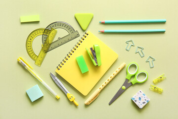 Different school stationery and notebook on green background