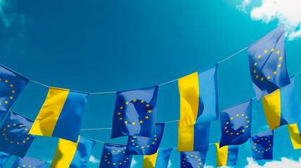Flags of European Union anf flags of Ukraine against the sky, flags hanging vertically