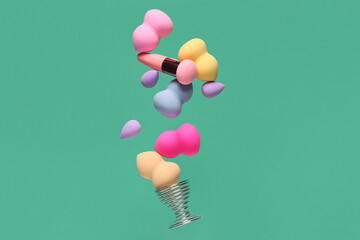 Flying different makeup sponges on green background