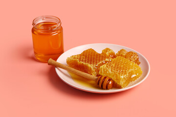 Jar of sweet honey and plate with combs on red background