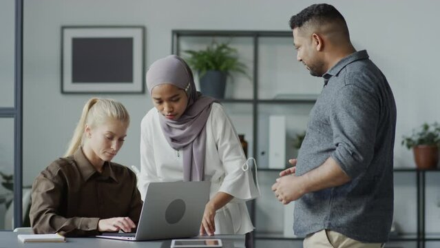 Two women ignoring their male co-worker on purpose when he trying to discuss new project with them, workplace bullying conceptTwo women ignoring their male co-worker on purpose when he trying to discu