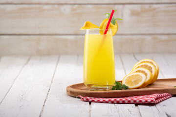 Cold lemonade, lemon slice and mint leaves on white wooden table