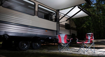 RV with awning open and chairs underneath