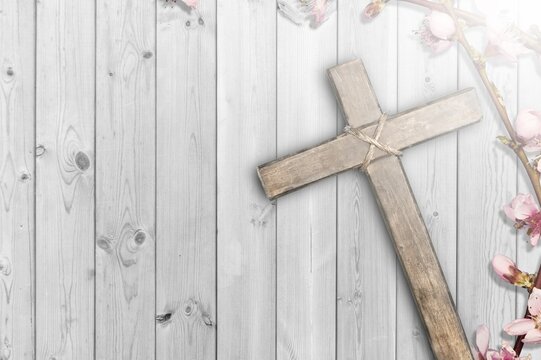 Christian wooden cross with fresh flower branches blossoms