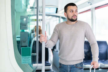 Fototapeta na wymiar Portrait of male passenger in tram car on a spring day