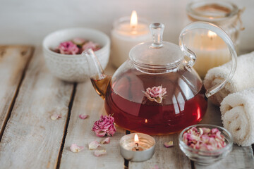 Obraz na płótnie Canvas Aromatherapy. Organic natural floral, plant ingredients for spa treatment in salon. Rose petals, essential oil, burning candles, towels, delicious herbal tea, Atmosphere of relax, detention.