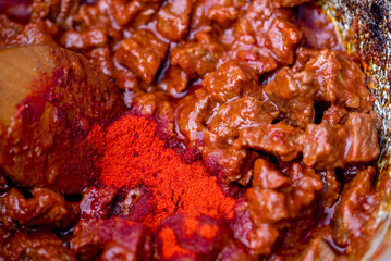 Traditional goulash soup is cooking in the a cauldron.