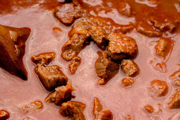 Obraz premium Traditional goulash soup is cooking in the a cauldron.