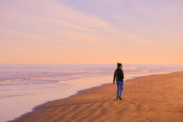 girl walking in a Scenery of beach during sunset or sunrise. Golden hours, pink background

