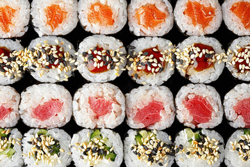 Sushi rolls in assortment on a black background. Close up