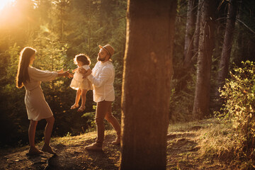 Young happy family playing in sunny mountains