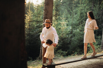 Young family near the bench in sunny forest