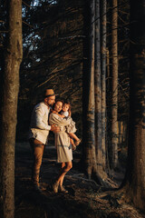 Happy family with little daughter in the forest