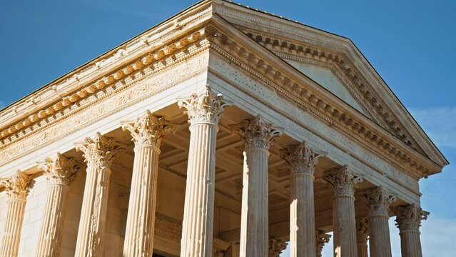The Roman temple in Nimes, Occitanie, France on a sunny summer day. Antique temple decorated with columns and friezes in France.
