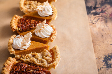 Variety of Thanksgiving pie slices on parchment paper