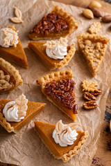 Variety of Thanksgiving pie slices on parchment paper