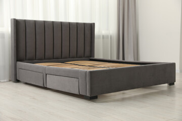 Modern bed with storage space for bedding under slatted base in room - obrazy, fototapety, plakaty