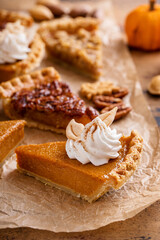 Variety of Thanksgiving pie slices on parchment paper