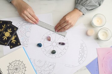 Astrologer using zodiac wheel for fate forecast at table, top view. Fortune telling